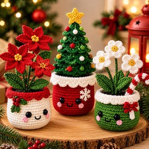 Puede incluir: Tres plantas en maceta de ganchillo que incluyen una flor de pascua roja, un árbol de Navidad verde con una estrella amarilla y flores blancas con un bastón de caramelo. Cada maceta tiene una cara sonriente, mejillas rosadas y un borde blanco.