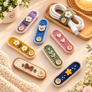 May include: A collection of rectangular crochet cable organizers in various colors including purple, blue, yellow, green, pink, white, and dark blue. Each features a wooden button closure and decorative motifs like flowers, a bear, hearts, a bow, and a star.