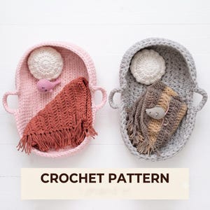 May include: Two oval crochet baskets with handles, one light pink and one light gray. The pink basket contains a white circular crochet piece, a small pink whale, and a terracotta fringed blanket. The gray basket holds a white circular crochet piece, a small gray mouse, and a brown striped fringed blanket. Text reads CROCHET PATTERN.