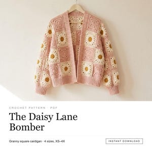May include: A crochet cardigan featuring a granny square pattern with daisy motifs in white and yellow on a soft pink background. The garment has long sleeves, a ribbed hem, and ribbed cuffs. Text reads: CROCHET PATTERN PDF The Daisy Lane Bomber.