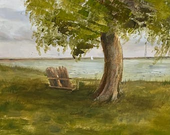 May include: Oil painting of a serene lakeside scene. A large tree with green foliage shades a wooden chair on a grassy bank. The water reflects the sky, with sailboats in the distance. The artwork is signed in the lower right corner.