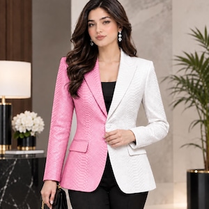 May include: A two-toned blazer featuring a split design with one side in bright pink and the other in white. The fabric has a textured snakeskin pattern throughout, including notched lapels, long sleeves, and two front flap pockets.