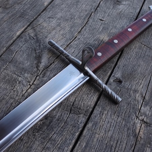 May include: A sword with a polished steel blade featuring a small star engraving near the crossguard. The crossguard has a twisted metal texture and a ring loop. The handle is made of dark reddish-brown wood secured with four silver-colored rivets.