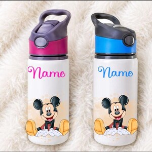 May include: Two white water bottles with flip-top lids. The left bottle has a magenta lid and the word Name in magenta script. The right bottle has a blue lid and the word Name in blue script. Both feature a graphic of Mickey Mouse sitting.