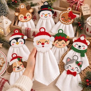 May include: A collection of white hanging kitchen towels featuring embroidered felt toppers shaped like holiday characters including Santa, a snowman, a reindeer, a penguin, a gingerbread person, an elf, a polar bear, a dog, and a cat.