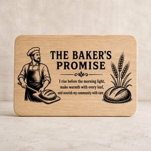 Peut inclure: Une planche à découper rectangulaire en bois clair avec une gravure noire représentant un boulanger tenant une pelle à pain, des épis de blé et le texte : THE BAKER'S PROMISE, I rise before the morning light, make warmth with every loaf, and nourish my community with care.