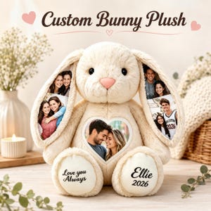 Puede incluir: Un peluche de conejo color crema con fotos personalizadas impresas en sus largas orejas y un parche en forma de corazón en el pecho. El pie izquierdo tiene impreso el texto Love you Always y el derecho el nombre Ellie y el año 2026.