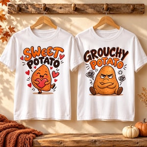 Puede incluir: Dos camisetas blancas de manga corta colgadas en perchas de madera. La camiseta izquierda muestra una patata dulce de dibujos animados con un corazón y el texto SWEET POTATO. La derecha muestra una patata gruñona con el texto GROUCHY POTATO.