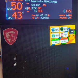 Puede incluir: Una torre de ordenador negra con una pantalla superior grande que muestra métricas de rendimiento del sistema como temperaturas de CPU y GPU, y una pantalla lateral más pequeña con un gráfico de consola de juegos amarilla.