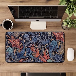 May include: A rectangular desk mat featuring a dark blue background with a repeating pattern of marine life including sharks, sea turtles, jellyfish, and coral. The creatures are illustrated with white constellation-style lines and dots.