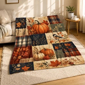 May include: A rectangular throw blanket featuring a patchwork design with autumn-themed illustrations. The pattern includes orange pumpkins, colorful fall leaves, plaid sections in red and blue, and a small bird perched on a branch.