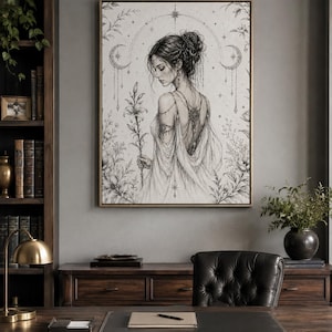 Puede incluir: Una impresión de arte lineal en blanco y negro enmarcada que representa a una persona con peinado recogido, vistiendo un vestido drapeado con detalles intrincados en la espalda, sosteniendo una flor de lirio. El fondo incluye motivos celestiales.