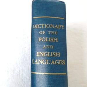 May include: A teal-colored book spine with gold lettering. The text reads "DICTIONARY OF THE POLISH AND ENGLISH LANGUAGES". Gold horizontal lines are at the top and bottom of the text.