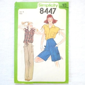 May include: A vintage Simplicity sewing pattern, number 8447, featuring illustrations of a woman in a yellow top and blue shorts, and another in a plaid shirt and tan pants. The pattern is on a green and white background.