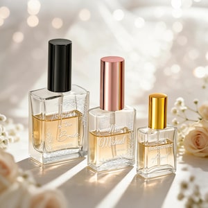 May include: Three rectangular glass perfume bottles with spray nozzles and caps in black, rose gold, and gold. The bottles are etched with the text Mother of the Bride, Mrs. Michael, and Bridesmaid, accompanied by delicate floral leaf patterns.