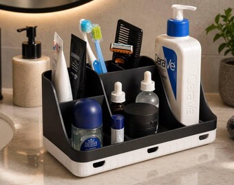 May include: A black and white multi-compartment bathroom organizer holding various personal care items including a large CeraVe pump bottle, two toothbrushes, a razor, a comb, dropper bottles, a small jar, and a blue-capped container.
