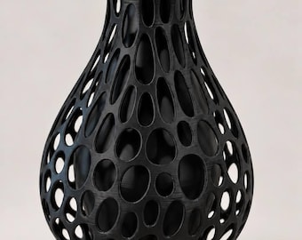 May include: A black vase with a bulbous shape and a narrow neck, featuring an intricate, open-work lattice structure composed of numerous oval-shaped cutouts that reveal a solid black inner core throughout the entire exterior surface.