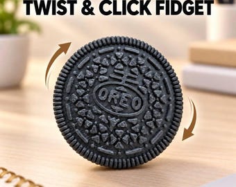 May include: A black circular fidget toy designed to resemble a sandwich cookie with the text OREO embossed in the center. The toy features a textured surface with geometric patterns and two brown arrows indicating a twisting motion. Text reads TWIST & CLICK FIDGET.