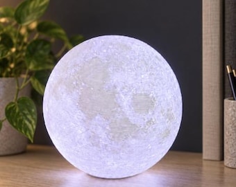 May include: A spherical moon lamp featuring a textured, cratered surface that emits a bright, cool white light. The lamp is round and displays detailed lunar topography across its entire exterior, providing an even glow from within the structure.