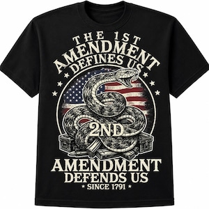 May include: A black t-shirt featuring a graphic of a coiled rattlesnake over an American flag background. The text reads THE 1ST AMENDMENT DEFINES US, 2ND AMENDMENT DEFENDS US, and SINCE 1791. The design includes ammunition boxes and bullets.