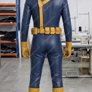 May include: A full-body blue jumpsuit costume featuring a yellow utility belt with multiple pouches, a yellow shoulder strap, yellow gloves, and yellow boots. The outfit is displayed on a mannequin, showcasing a smooth, fitted design with visible seams.