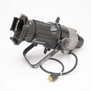 May include: A black stage spotlight with a curved handle and a power cord. The spotlight has a cylindrical body with a lens at the front and a fan at the back. The spotlight is on a white background.