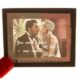 May include: Vintage black and white slide featuring a romantic scene of a man and woman, with text "You were meant for me, I was meant for you." The slide is labeled "Song-Hit Slides" and includes the number 19.