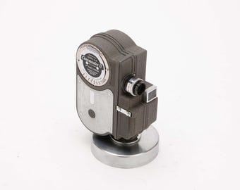 Cámara de cine UNIVERSAL Modelo G-8 - Diseño Art Déco aerodinámico - Cuerpo de metal fundido a presión - Con soporte