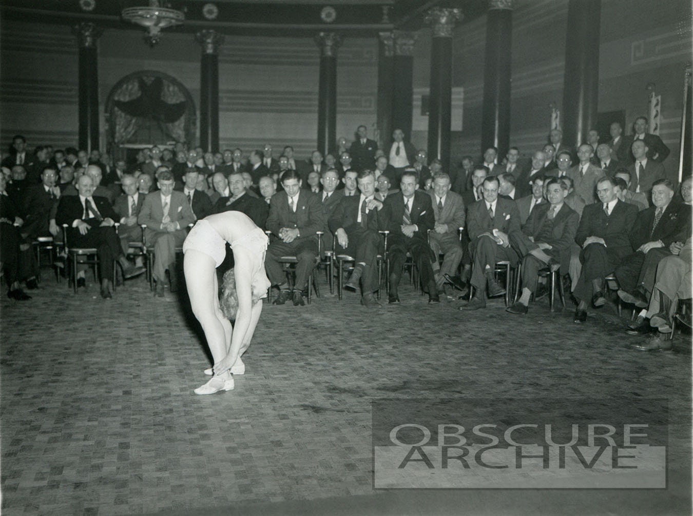 THE CONTORTIONIST - 1930s - men watch as a young woman displays her flexibility - B&W Photograph