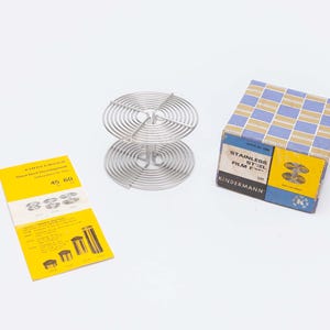 May include: A set of three ceramic mugs with a speckled, matte finish. The mugs are in shades of cream, light gray, and dark gray. Each mug has a simple, minimalist design, perfect for coffee or tea.