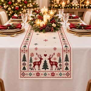 May include: A cream-colored table runner featuring a repeating pattern of red reindeer, green pine trees, and red snowflakes. The runner is centered on a white tablecloth and decorated with a festive centerpiece of candles and greenery.