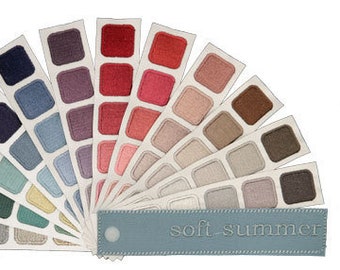 Pode incluir: Um leque de paleta de cores com uma variedade de cores suaves, incluindo tons de cinza, azul, verde e rosa. O leque é etiquetado como "soft-summer".