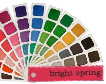 May include: A color palette fan with 12 different color swatches, each with three shades of the same color. The colors are arranged in a fan shape, with the darkest shades at the bottom and the lightest shades at the top. The colors are all bright and vibrant, and the palette is labeled "bright spring".
