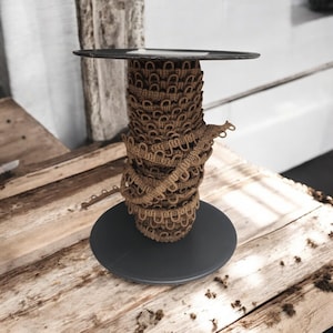 Peut inclure: Une bobine de galon brun avec un motif en boucle. Le galon est enroulé autour d'une base circulaire noire.