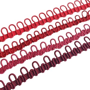 May include: Four rows of red, burgundy and maroon elastic trim with loops. The trim is made of a soft, woven fabric and is perfect for adding a touch of elegance to any project.