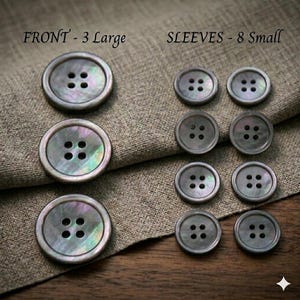 May include: A collection of gray buttons with four holes each. The image shows three large buttons and eight smaller buttons. The text on the image reads "FRONT - 3 Large" and "SLEEVES - 8 Small".