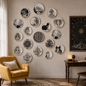 Può includere: Una collezione di quindici piatti da parete circolari con intricate illustrazioni in bianco e nero di motivi celesti, animali e naturali, disposti in un gruppo su una parete accanto a una grande stampa rettangolare incorniciata di una carta solare e lunare.