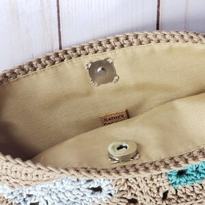 Puede incluir: El interior de un bolso de crochet con un forro beige. El bolso tiene una etiqueta de cuero marr&oacute;n que dice "Kathy's Creations".