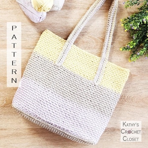 May include: A crocheted tote bag in a gradient of colours, fading from pale yellow to grey and lavender. It has long handles and the word "PATTERN" is displayed vertically on the left. The text "Kathy's Crochet Closet" is on the right.