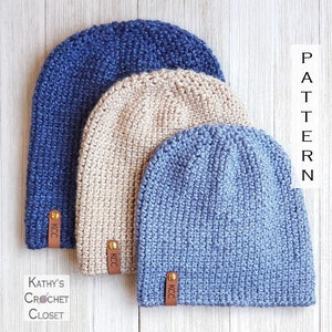 May include: Three crocheted beanies in different colors: navy blue, beige, and light blue. Each beanie has a leather tag with the text "KCC" on it.