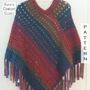Puede incluir: Un poncho de ganchillo con rayas diagonales en tonos marr&oacute;n, azul y rojo con flecos en el borde inferior. El texto Kathy's Crochet Closet y la palabra PATTERN son visibles en la imagen.