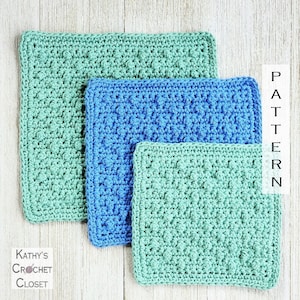 Könnte beinhalten: Drei gehäkelte Quadrate in verschiedenen Größen, eines grün, eines blau und eines kleineres grün. Die Quadrate sind übereinander gestapelt, wobei das größte Quadrat unten und das kleinste Quadrat oben liegt. Die Quadrate sind mit einem strukturierten Stich gearbeitet, der eine unebene Oberfläche erzeugt. Der Text "PATTERN" ist vertikal auf der rechten Seite des Bildes geschrieben.