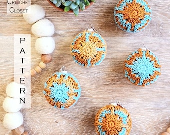 Puede incluir: Seis adornos navideños hechos a mano con ganchillo en tonos naranja y azul turquesa, dispuestos sobre una superficie de madera. Los adornos tienen un diseño de estrella. La imagen también incluye una guirnalda de bolas de fieltro blancas y el texto "Kathy's Crochet Closet" y "Pattern".