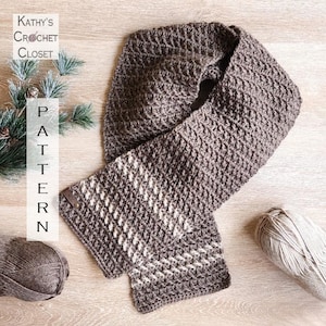 May include: A handmade, textured crochet scarf in shades of gray and white, with a repeating diamond pattern. The scarf is displayed on a wooden surface with two balls of yarn and the text "Kathy's Crochet Closet Pattern".