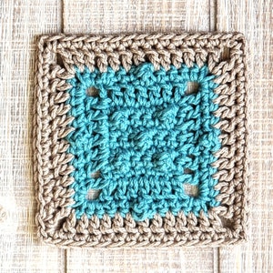 Puede incluir: Un cuadrado tejido a crochet con un centro turquesa y un borde marr&oacute;n. El cuadrado est&aacute; hecho con un patr&oacute;n de punto de abuela.