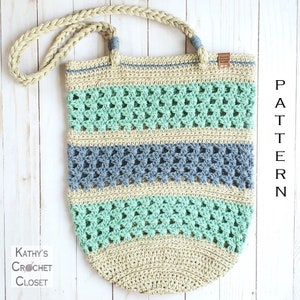 May include: A crocheted tote bag with a beige, green, and blue striped pattern. The bag has a braided strap and a brown leather tag with the text "Kathy's Crochet Closet".