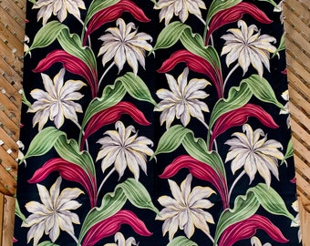 May include: Black fabric with a repeating pattern of white flowers and red leaves. The fabric has a tropical feel.
