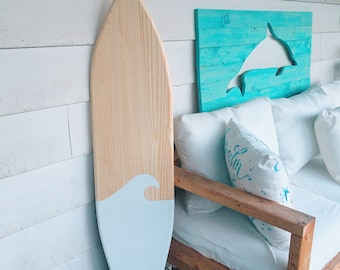 4 foot wood surfboard wall art with natural blonde pine wood base and a white wave bottom