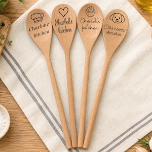 May include: Four light-coloured wooden spoons with long handles. Each spoon features black laser-engraved text reading Charlotte's kitchen. The bowls of the spoons display unique icons: a chef hat, a heart, a cupcake, and a puppy face.