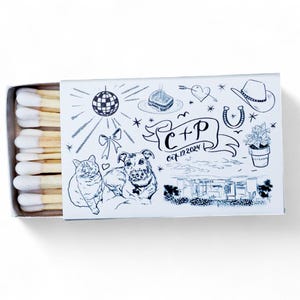 May include: A matchbox with a custom design featuring a disco ball, a cowboy hat, a horseshoe, and a drawing of a cat and a dog. The box also includes the initials "C + P" and the date "Oct 12, 2024".